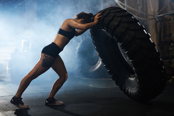 Strong woman flipping tyre  - Photo, Image