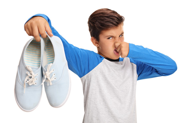 Boy holding pair of smelly shoes - Φωτογραφία, εικόνα