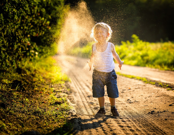Boy playing on country rural road. - Photo, Image