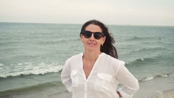 Ελκυστικό κορίτσι στο seacoast σε γυαλιά ηλίου - Πλάνα, βίντεο