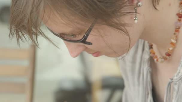 It is close-up image of concentrated female artist working. - Video