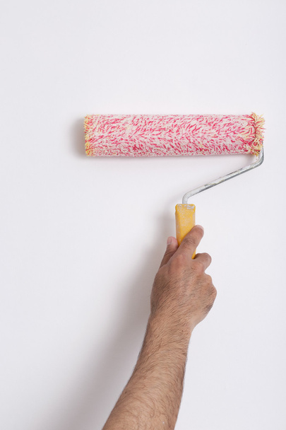 Close up of painter arm painting a wall with paint roller - Photo, Image