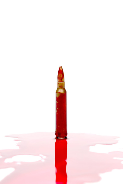 A rifle bullet with red blood  - Photo, Image