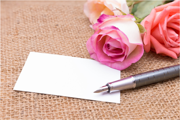 χαρτί σημείωμα με τριαντάφυλλο στην τσάντα gunny (Διοργανωτής, ατζέντα, βιβλίο, ημερολόγιο, κάρτα) - Φωτογραφία, εικόνα