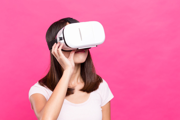Mujer mirando a través de dispositivo VR
 - Foto, Imagen