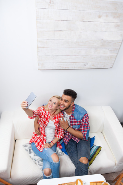 Пара робить селфі фотографію дівчини, що тримає смартфон, сидячи в кав'ярні диван верхній кут
 - Фото, зображення