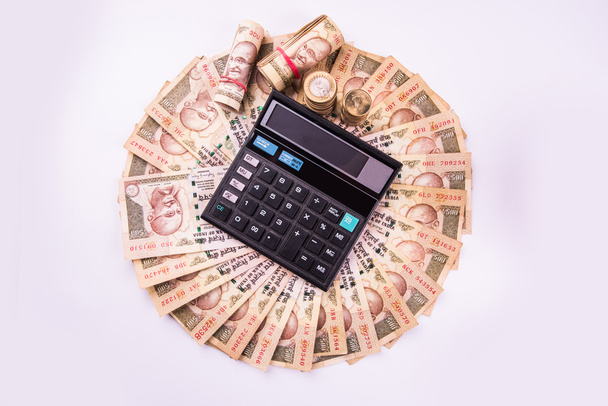 indyjskie notatki walutowe ułożone w okrągłym kształcie z kalkulatorem nad nim - Zdjęcie, obraz