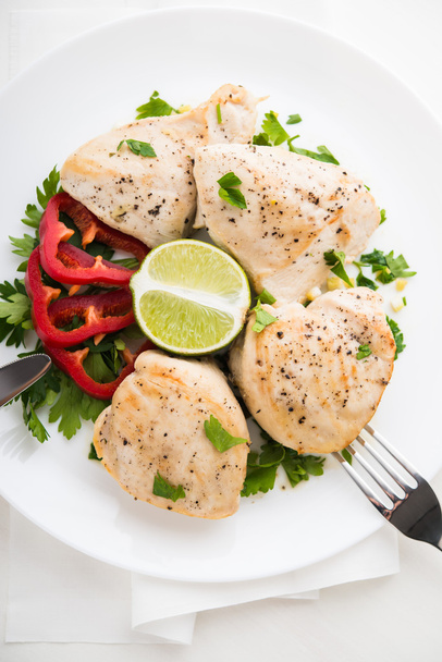 Hühnerbrust mit Petersilie, Pfeffer und Zitrusfrüchten auf weißem Holzhintergrund von oben. gesunde Ernährung. - Foto, Bild