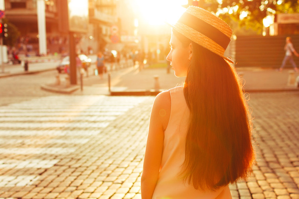 Fashionable girl in the sunny city stands near the road - Photo, Image