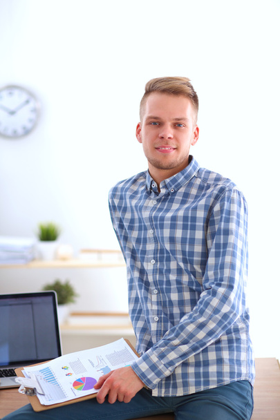 Young businessman working in office, sitting at desk - Photo, image