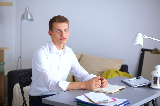 Young businessman working in office, sitting near desk - Foto, afbeelding