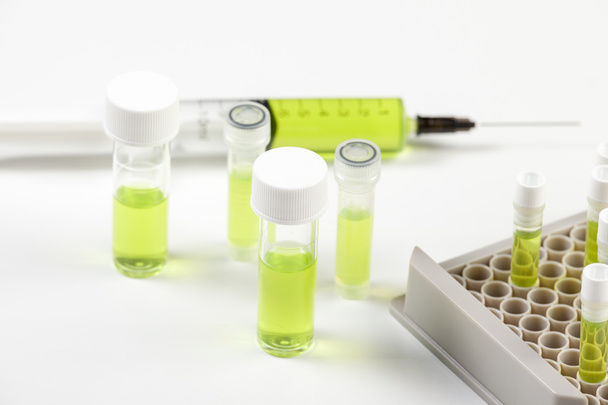 Flacons et seringues fermés contenant du liquide vert
 - Photo, image