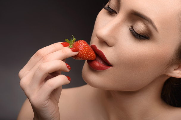 赤いベリーを食べる大胆な女の子 - 写真・画像