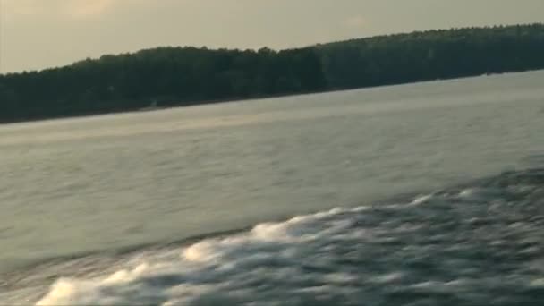 Water waves splashing behind speed boat, golden sunset - Кадры, видео