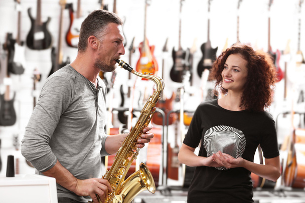 Man and woman in music shop - Фото, зображення