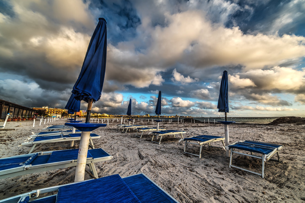блакитні пляжні парасольки на заході сонця
  - Фото, зображення