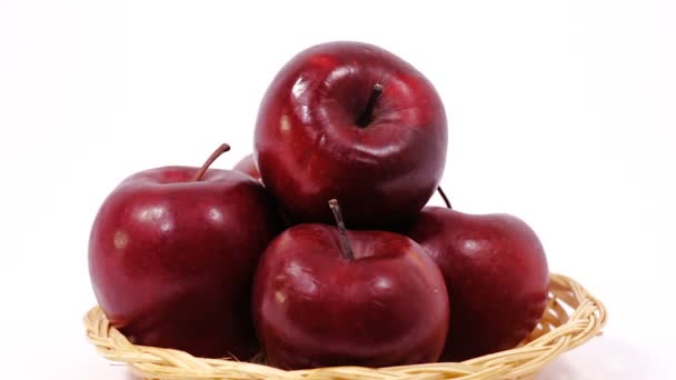 Hromadu zralé červené jablka v proutěném koši izolovaných na bílém pozadí - Záběry, video