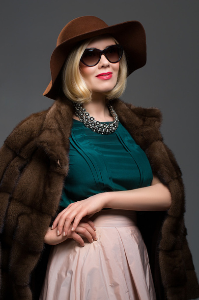 Beautiful mature woman in natural fur coat - Фото, изображение