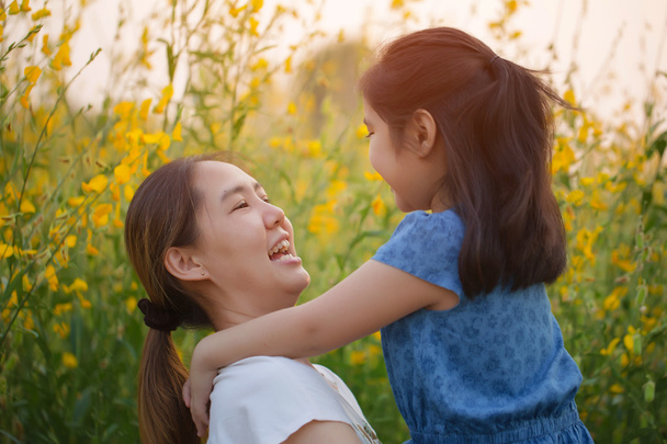 Heureuse fille asiatique et femme asiatique étreignant sur le champ de fleurs, concept de liberté
 - Photo, image