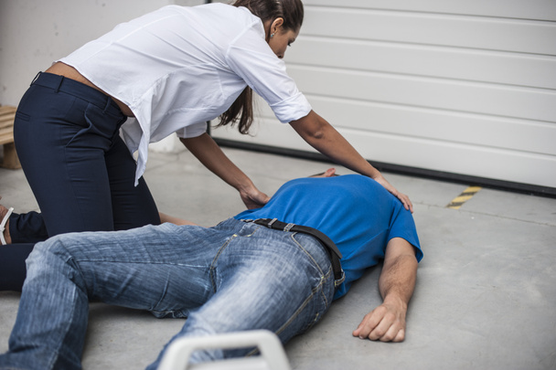 chica ayudando a un hombre inconsciente con desfibrilador
 - Foto, Imagen