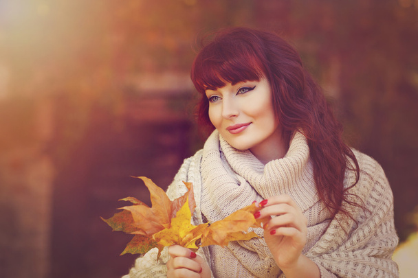 Красива дівчина на відкритому повітрі з осіннім листям
 - Фото, зображення