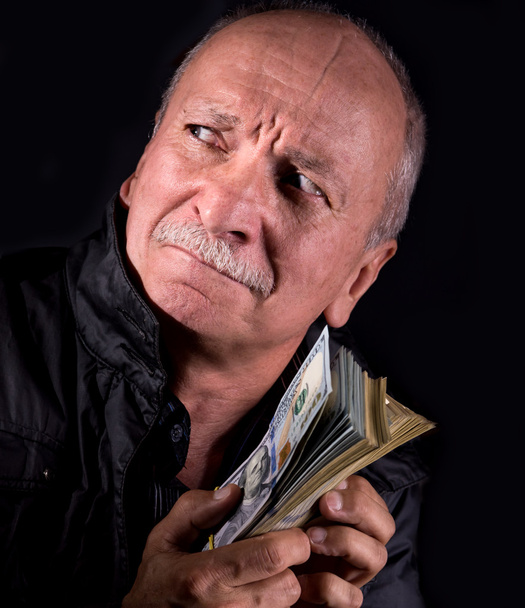 Sly homem sênior segurando notas de dólar
 - Foto, Imagem