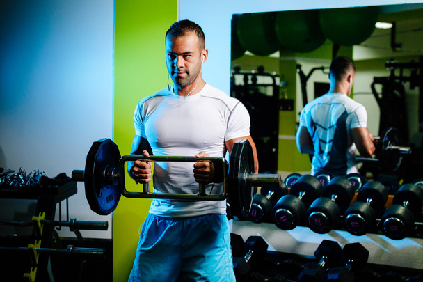 bodybuilder pumping up hands in gym - Photo, Image