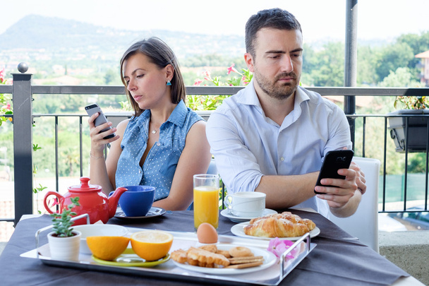 Набридла пара за допомогою смартфона під час сніданку
 - Фото, зображення