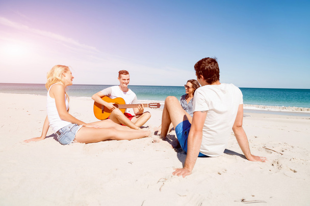 Beautiful young people with guitar on beach - 写真・画像