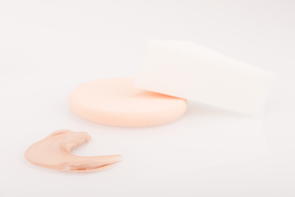 Crema de maquillaje teñido líquido movimiento de la muestra de fundación y esponjas
 - Foto, Imagen