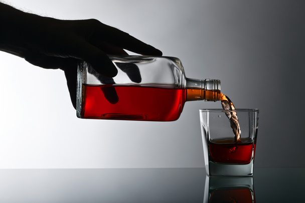 botella y vaso de whisky en una mesa de cristal
  - Foto, Imagen