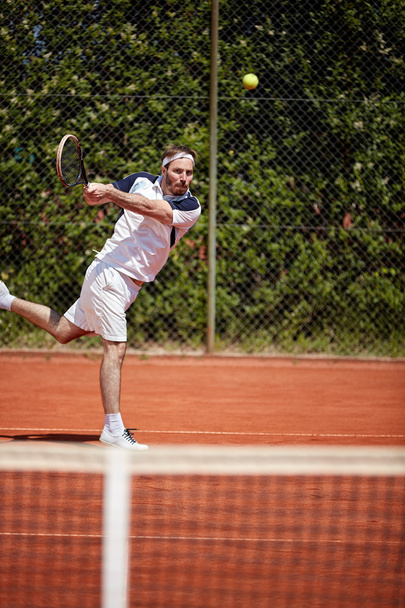Tennis player hitting tennis ball - Фото, зображення