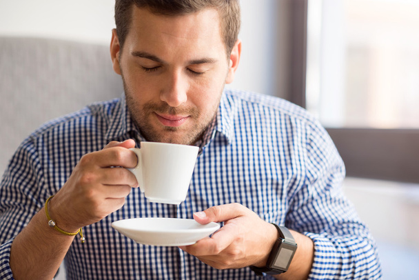 Delighted man drinking coffee - Фото, изображение