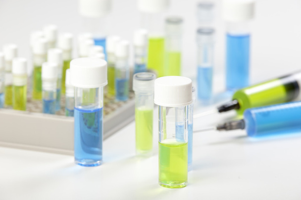 Seringues et flacons contenant des liquides bleus et verts
 - Photo, image
