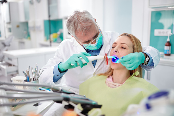 Dentiste utiliser instrument de lumière dentaire pour travailler
 - Photo, image