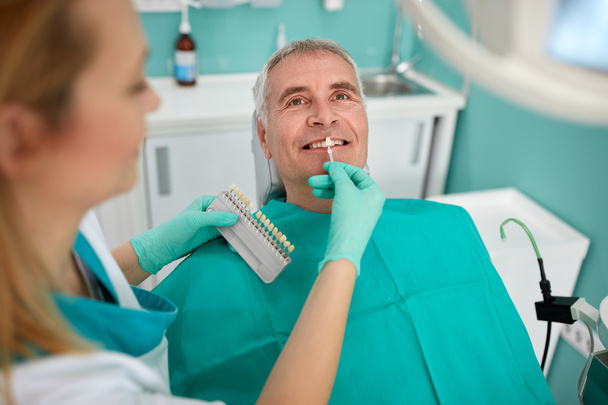 Мужчина в стоматологическом кресле с женщиной-стоматологом
 - Фото, изображение