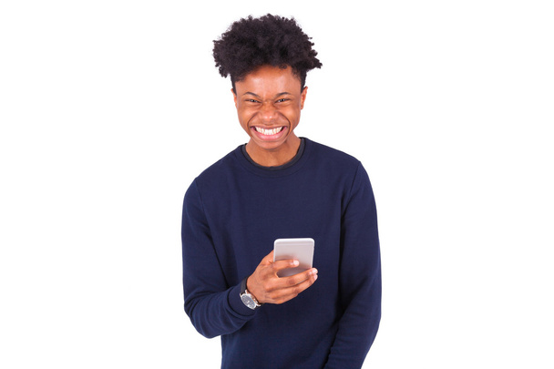 Young African American man sending a sms text message on his sma - Foto, immagini