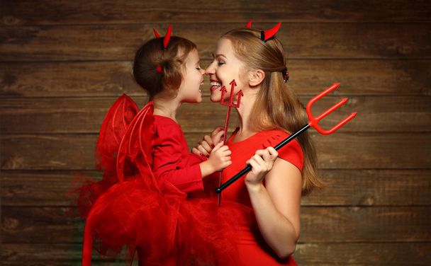 Family mother and child daughter celebrate Halloween in devil co - Foto, afbeelding