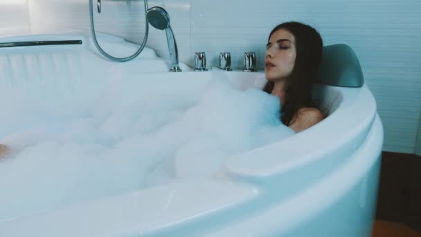 Chica morena acariciándose en la bañera llena de espuma. Disfruten. Satisfacción
 - Metraje, vídeo