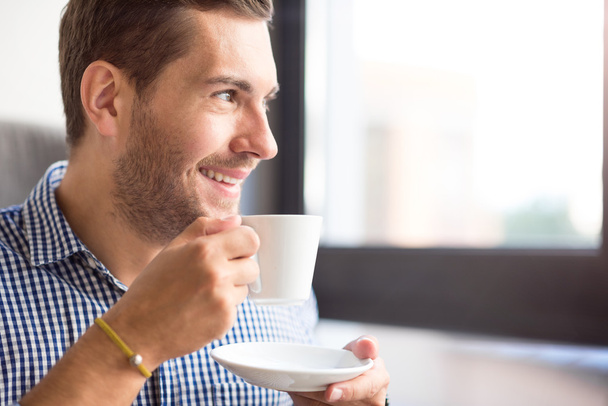 Cheerful man drinking coffee - Фото, зображення