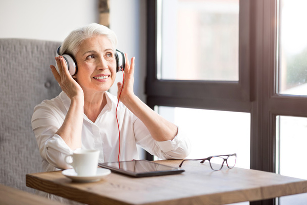 Positive senior woman listening to music - Zdjęcie, obraz