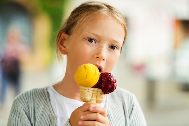мила маленька дівчинка їсть морозиво на відкритому повітрі
 - Фото, зображення