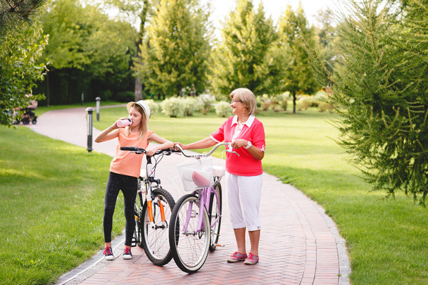 Active senior woman riding bike in a park - Photo, Image