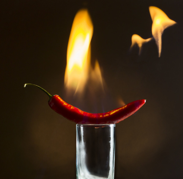 Red hot pepper with flames on the glass - Photo, Image