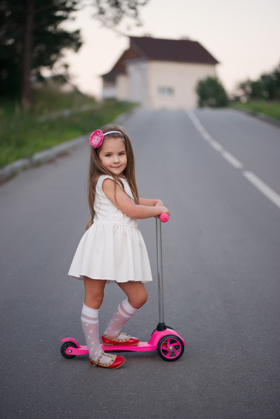 little girl with scooter on the road - Foto, Imagen