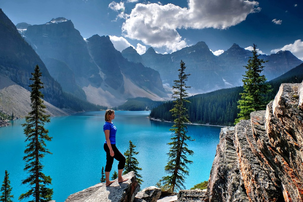 Женщина смотрит на озеро и горы
.  - Фото, изображение