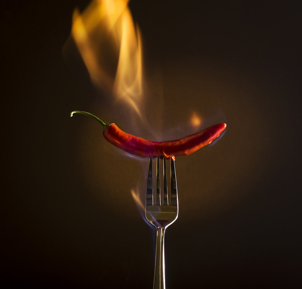 Piment rouge sur une fourchette avec feu
. - Photo, image