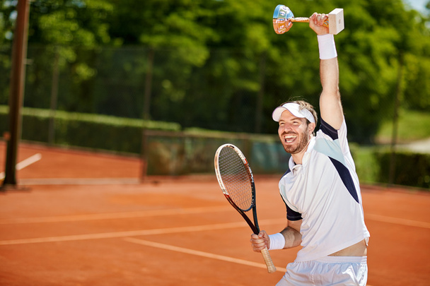 Happy tennis player with goblet and racket - Zdjęcie, obraz