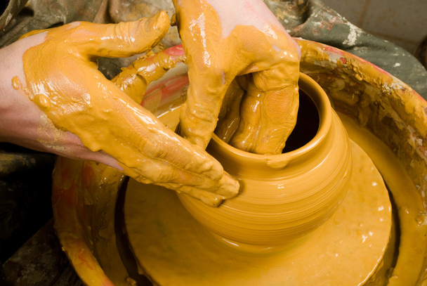 handen van een pottenbakker, maken een aarden pot van witte klei - Foto, afbeelding
