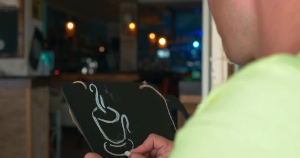 El hombre dibuja una tiza en una pizarra negra
 - Metraje, vídeo